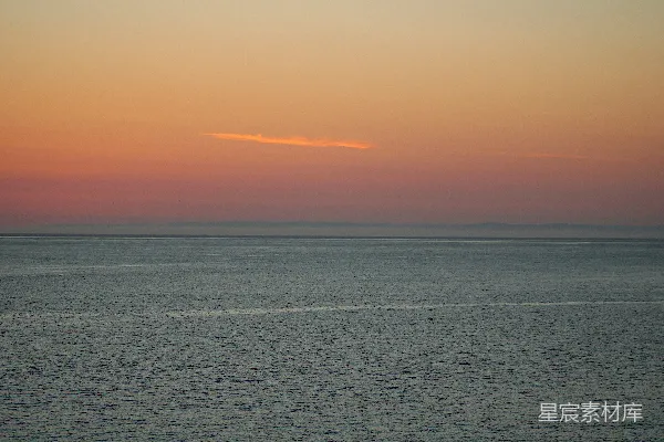 高清摄影 背景中有夕阳的一片广阔水域。