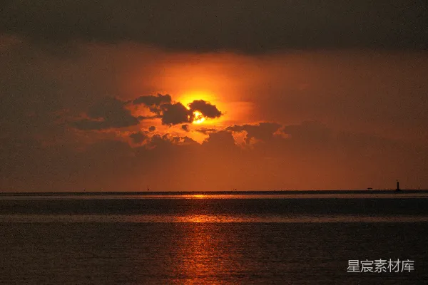 高清摄影 夕阳映照在海洋之上，云彩缭绕。