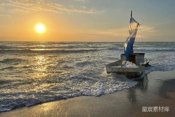 高清摄影 海边一艘帆船，夕阳西下背景中