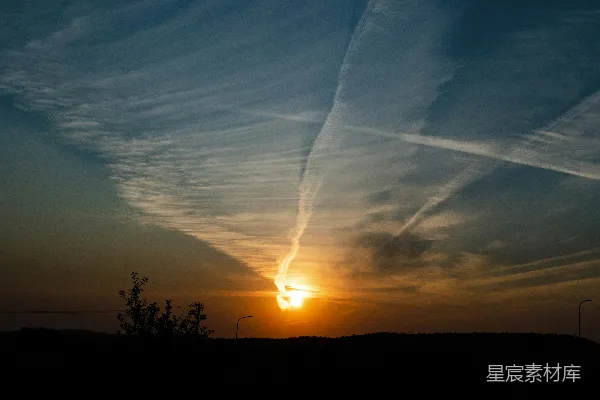高清摄影 天空中挂着夕阳和飞机尾迹的景象