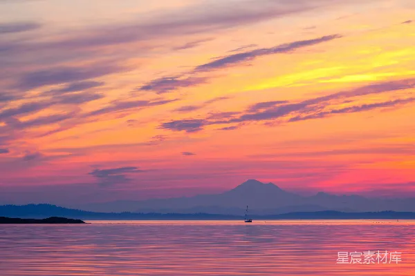 高清摄影 夕阳下水中的一叶小舟，背景是山峦。