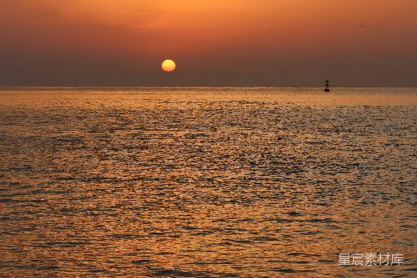 高清摄影 夕阳西下，海天一色，远处有一艘船只。
