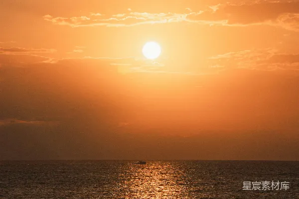 高清摄影 金色的夕阳映照在海边，一艘小船。
