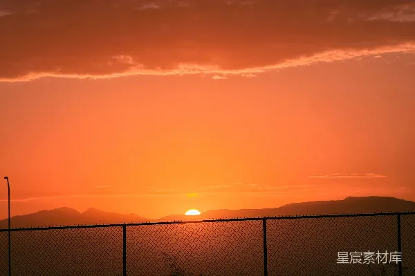 高清摄影 夕阳落在一道铁丝网围栏后面