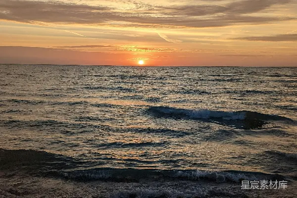 高清摄影 海滩上的太阳正在落下海平线。