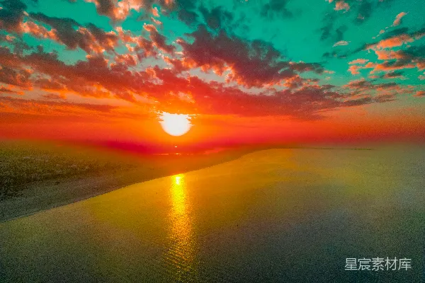 高清摄影 一片绚烂的夕阳映照在平静的大海上，天空中有色彩斑斓的云朵。
