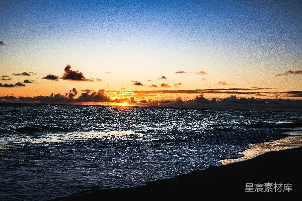 高清摄影 海浪在日落时分拍打着海滩。