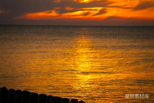 高清摄影 夕阳西下，海平面上有一座码头在 foreground。