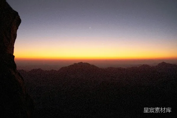 高清摄影 背景有一座山，夕阳映照在一片水面之上。