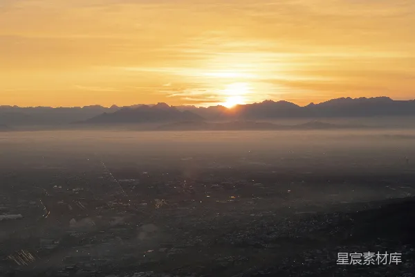 高清摄影 夕阳西下，城市背景中有山峦。