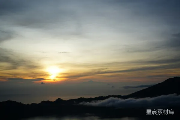高清摄影 夕阳西下，山脚下云雾缭绕。