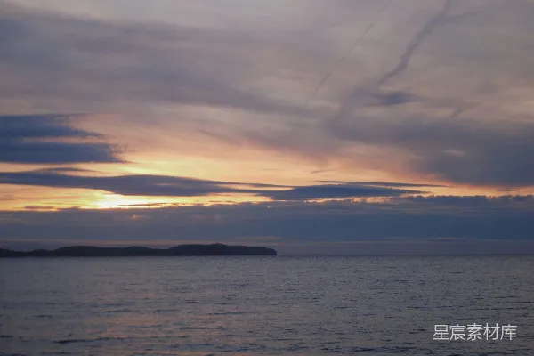 高清摄影 夕阳西下，海天相接处有山峦隐约可见。