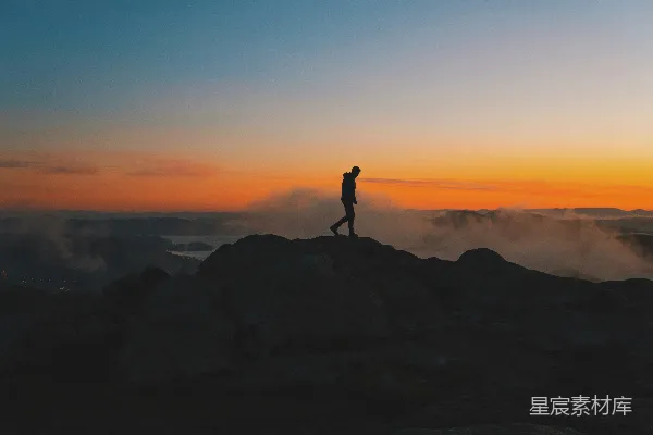 高清摄影 山顶上站立着一个人在夕阳下。