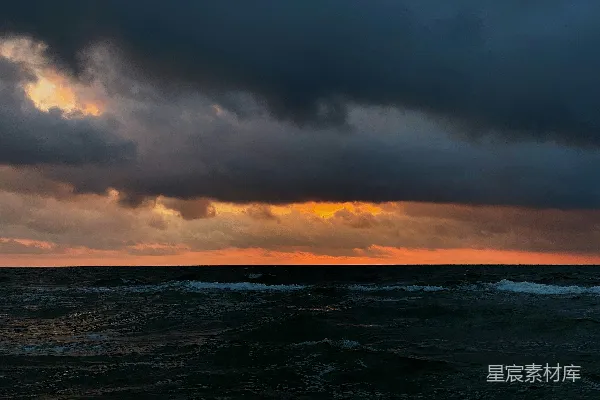 高清摄影 夕阳下的波涛起伏的海浪在阴云之中