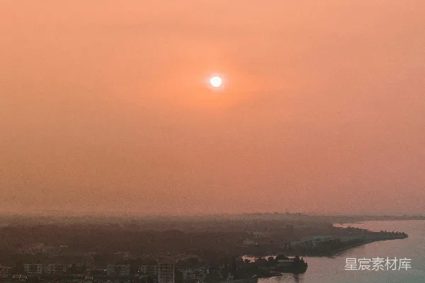 高清摄影 一片夕阳映照在远处城市的水面上。