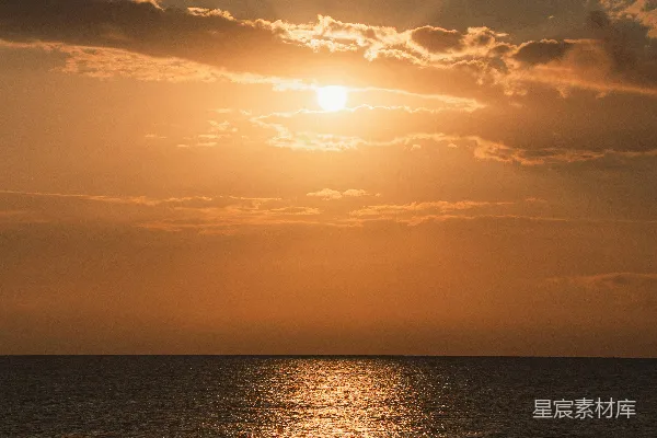 高清摄影 金色的夕阳照耀在大海之上，阳光透过云层洒落。