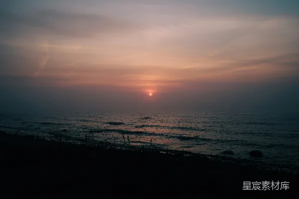 高清摄影 雾天，太阳正沉落在海面上。