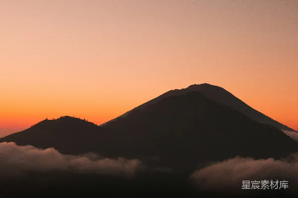 高清摄影 山中云雾缭绕，背景是日落。