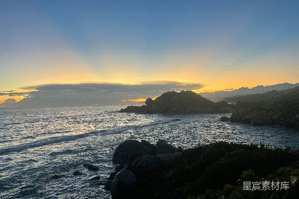 高清摄影 夕阳西下，海平线前岩石耸立。