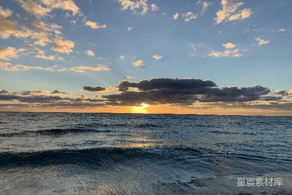 高清摄影 在阴天的日子里，太阳正 Setting 落在大海上。