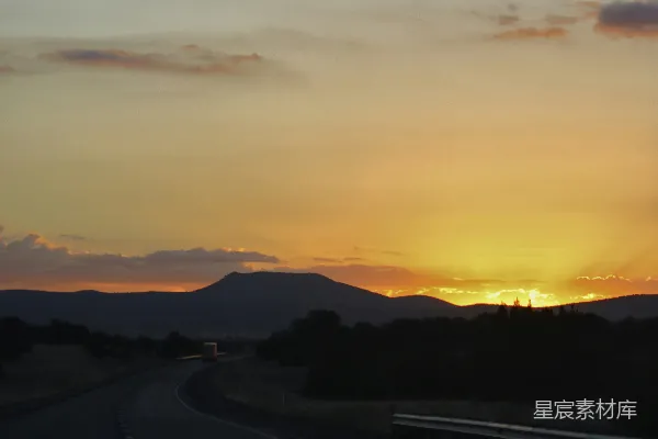 高清摄影 夕阳西下，背景是连绵的山脉。