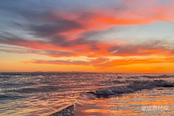 高清摄影 海边的日落，海浪拍打着沙滩。