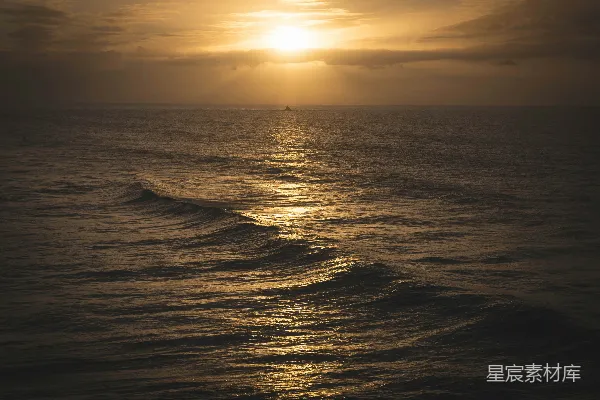 高清摄影 夕阳西下，海面上有一艘船在远处。