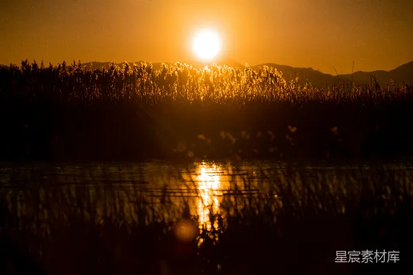 高清摄影 夕阳西下，映照在一片水域之上。