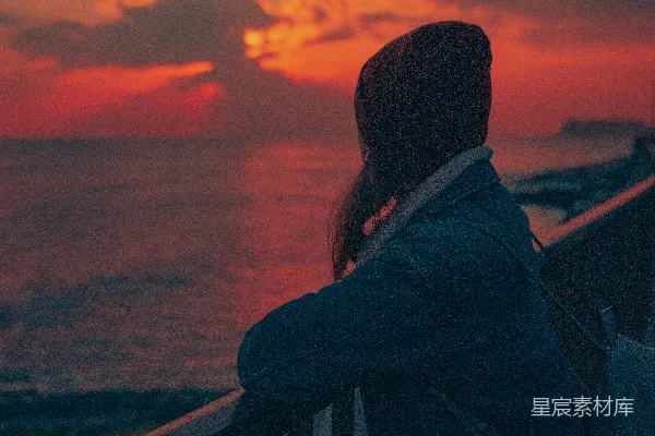 高清摄影 黑色夹克的男人站在夕阳下近 railing 处站立。
