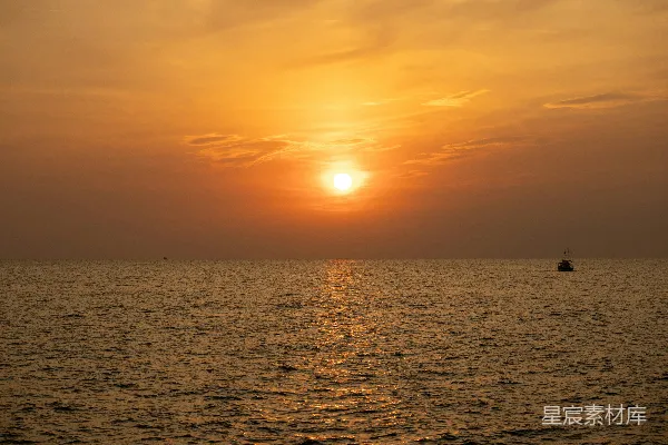 高清摄影 夕阳西下，海天相接处有一艘小船。