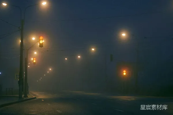 高清摄影 夜晚的一条雾气缭绕的街道，有街灯照明。
