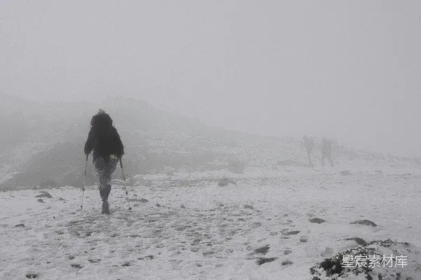 高清摄影 黑色风衣女子在覆有积雪的田野上白天行走