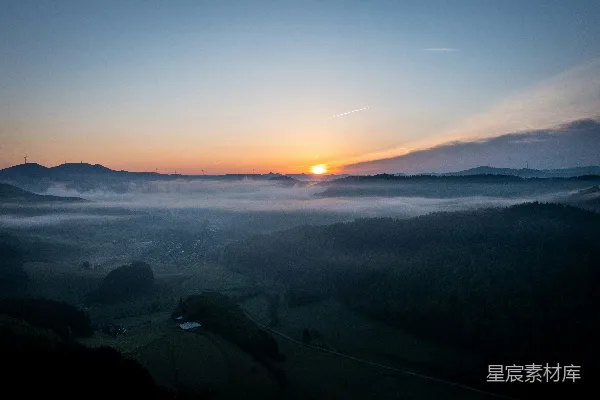 高清摄影 夕阳洒落于一片雾气缭绕的山谷之中