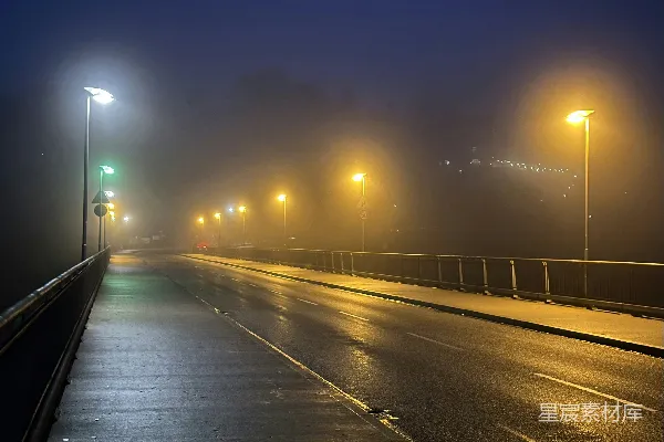 高清摄影 雾蒙蒙的夜晚在一条有路灯的道路行驶