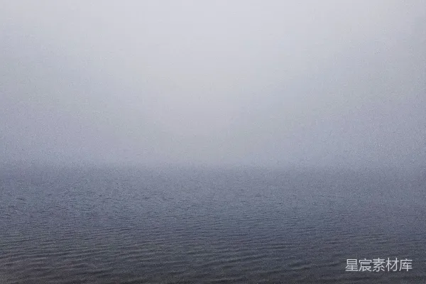 高清摄影 一片广阔的水域坐落在阴云密布的天空下。