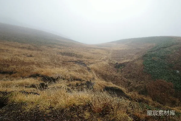 高清摄影 一片雾气缭绕的草地上有一座远山。