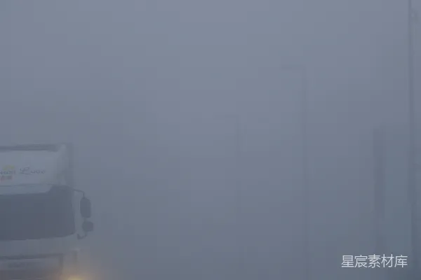 高清摄影 一辆卡车穿过一条公路上的浓雾行驶。