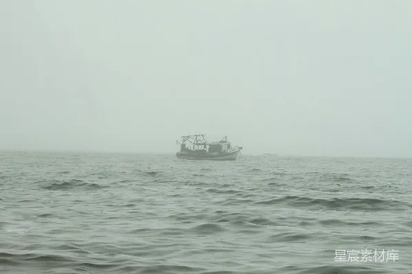 高清摄影 一艘船漂浮在雾天的大海中间。