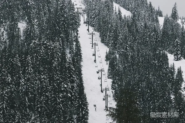 覆盖着白雪的山峦，一条滑雪索道通向山下。
