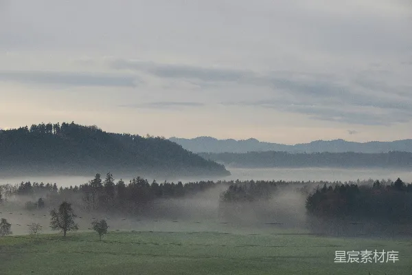高清摄影 背景中有树木和山峰的雾气笼罩之地