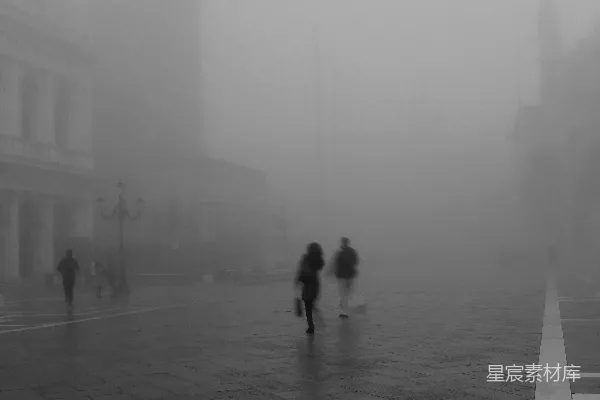 高清摄影 人们穿过一个雾气弥漫的城市环境。