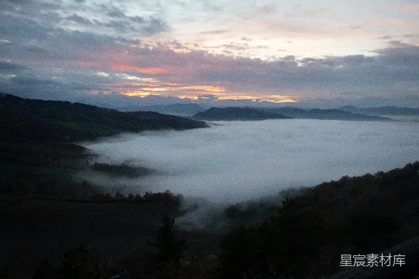 高清摄影 远处山峦间的一片雾气缭绕的山谷景色