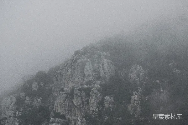高清摄影 一座被雾和低垂的云层覆盖的山峰