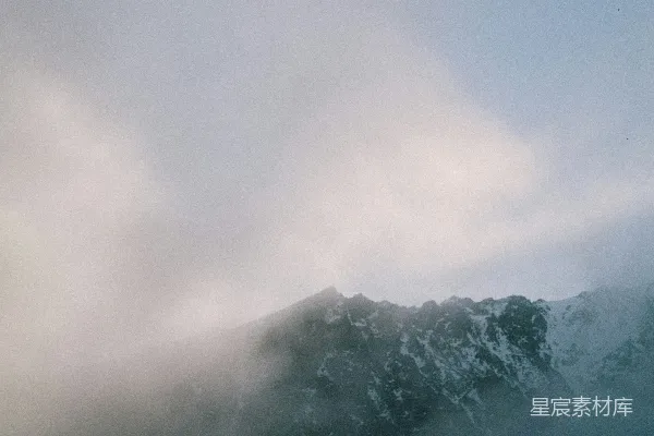 高清摄影 云层笼罩下一片被白雪覆盖的大山