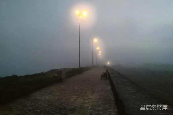 高清摄影 一个烟雾弥漫的小街，有长凳和路灯