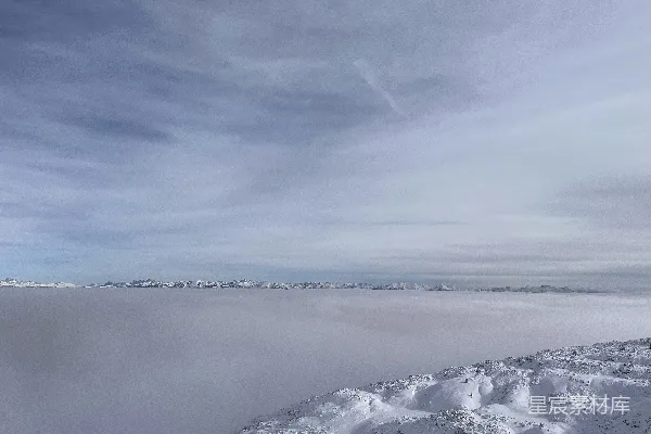 高清摄影 山顶上站立着一个人，身后覆盖着皑皑白雪。