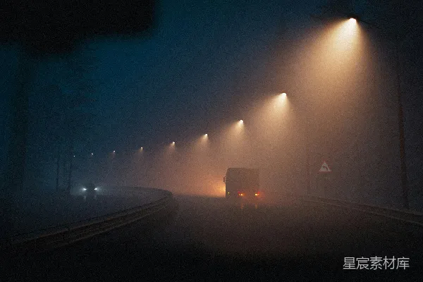 高清摄影 一辆卡车在夜晚的浓雾中行驶于一条小路上。