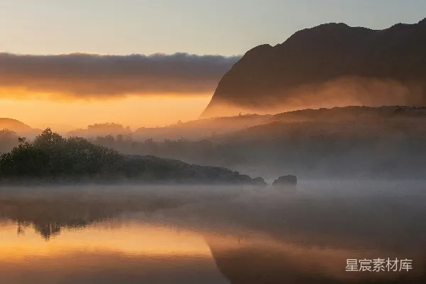 高清摄影 被山峦环绕着的一片水域，周围弥漫着雾气。
