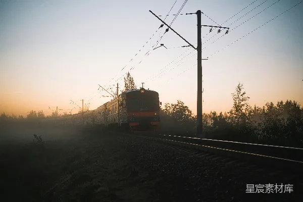 高清摄影 夕阳下火车在铁路上行驶，红白相间。