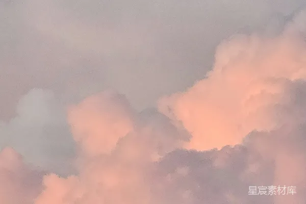 高清摄影 一架飞机穿过云层，云朵呈现出粉色。